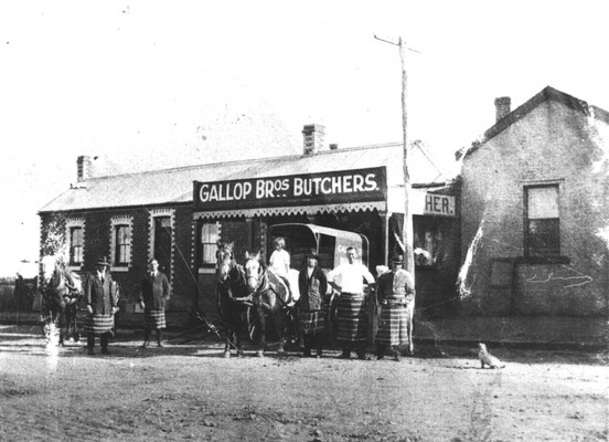 The butcher at Drysdale where Margaret Walters gained employment. Black and white photo with workers wearing striped aprons and a young girl on horseback. 