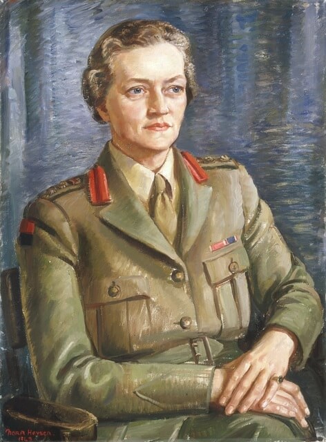 Picture of Sybil H Irving. She is seated with hands crossed on her lap. Wears a khaki military uniform with red stripes on the collar.