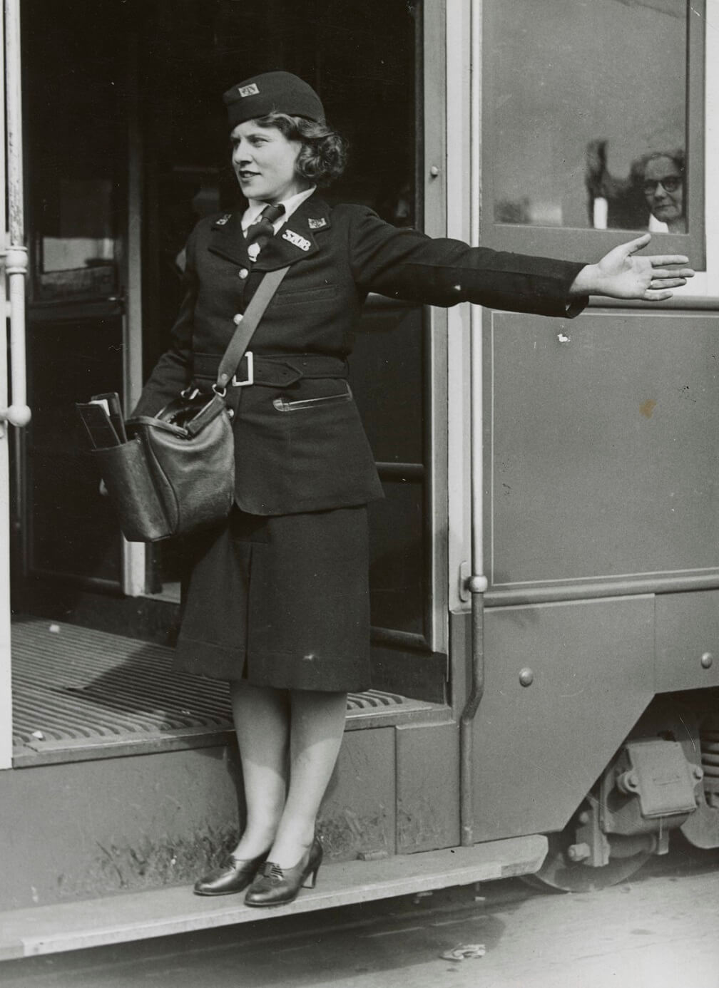 women conductress directing traffic from tram step