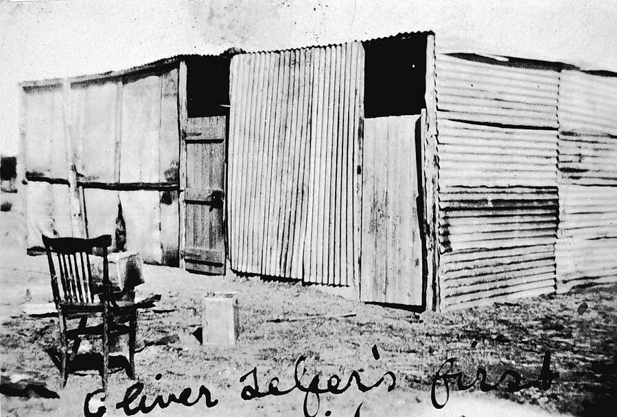 black and white photograph of a roughly constructed corrugated iron building