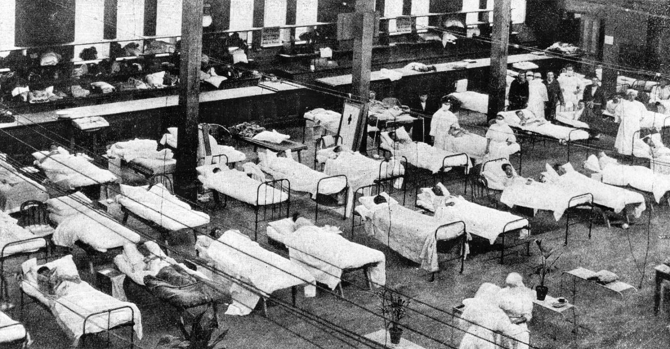 rows of camp bed in a makeshift hospital