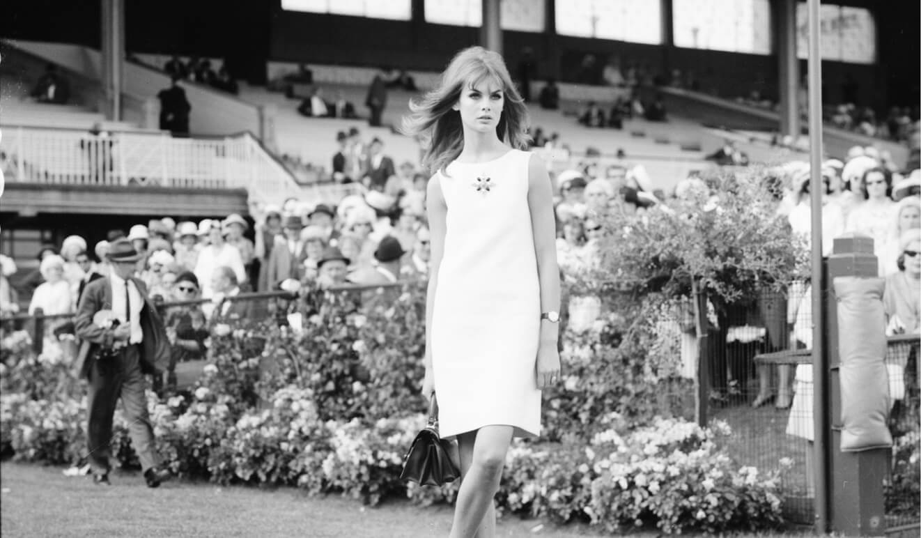 A woman wearing a short white dress poses for the camera.