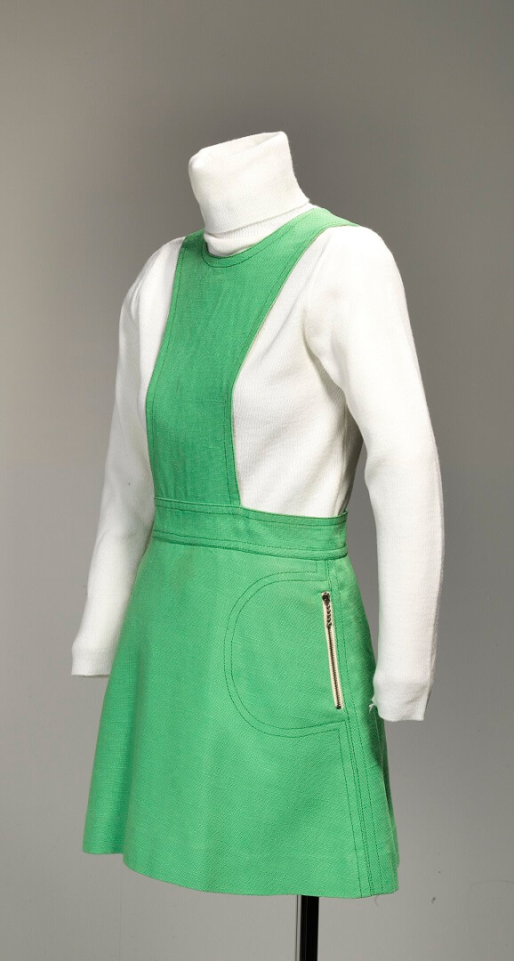 Lime green linen mini pinafore dress with zippered pockets on sides of skirt. The garment is lined with lime green polyester. The centre back opening is zippered from neck to buttocks.